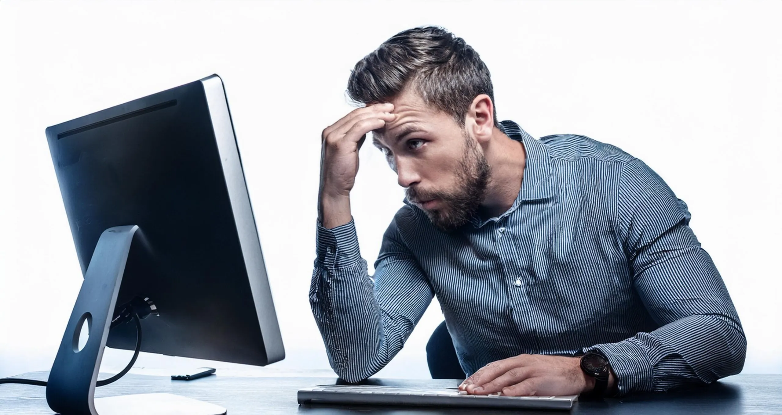 Man looking at a computer screen with a thoughtful expression, symbolizing the process of identifying and managing stagnant listings .
